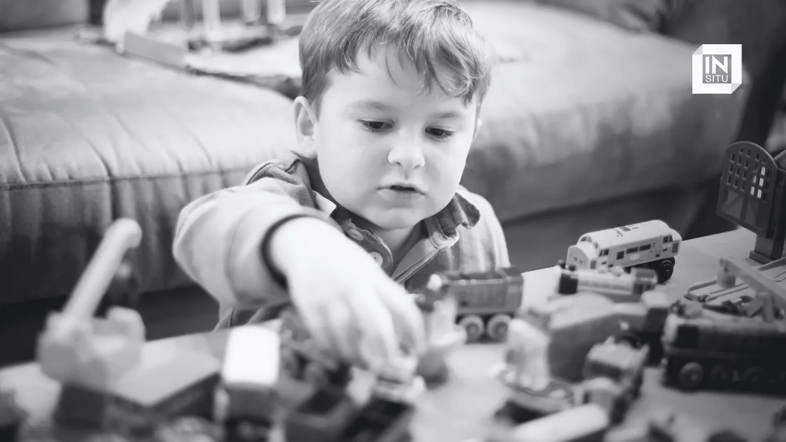 niño jugando con diversos juguetes en una mesa